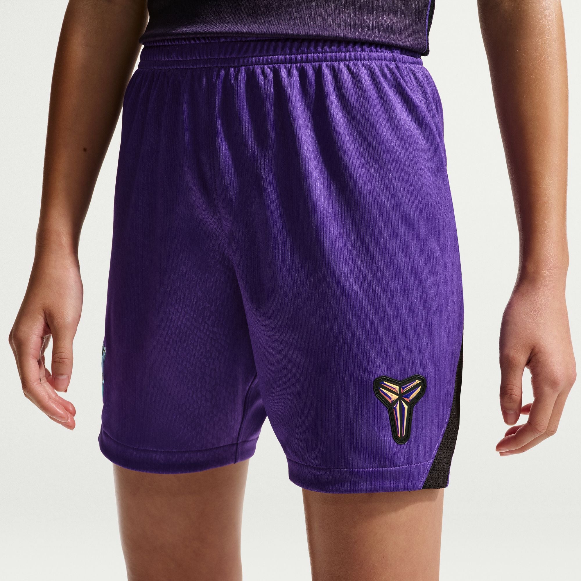 Purple athletic shorts with a logo on a plain background