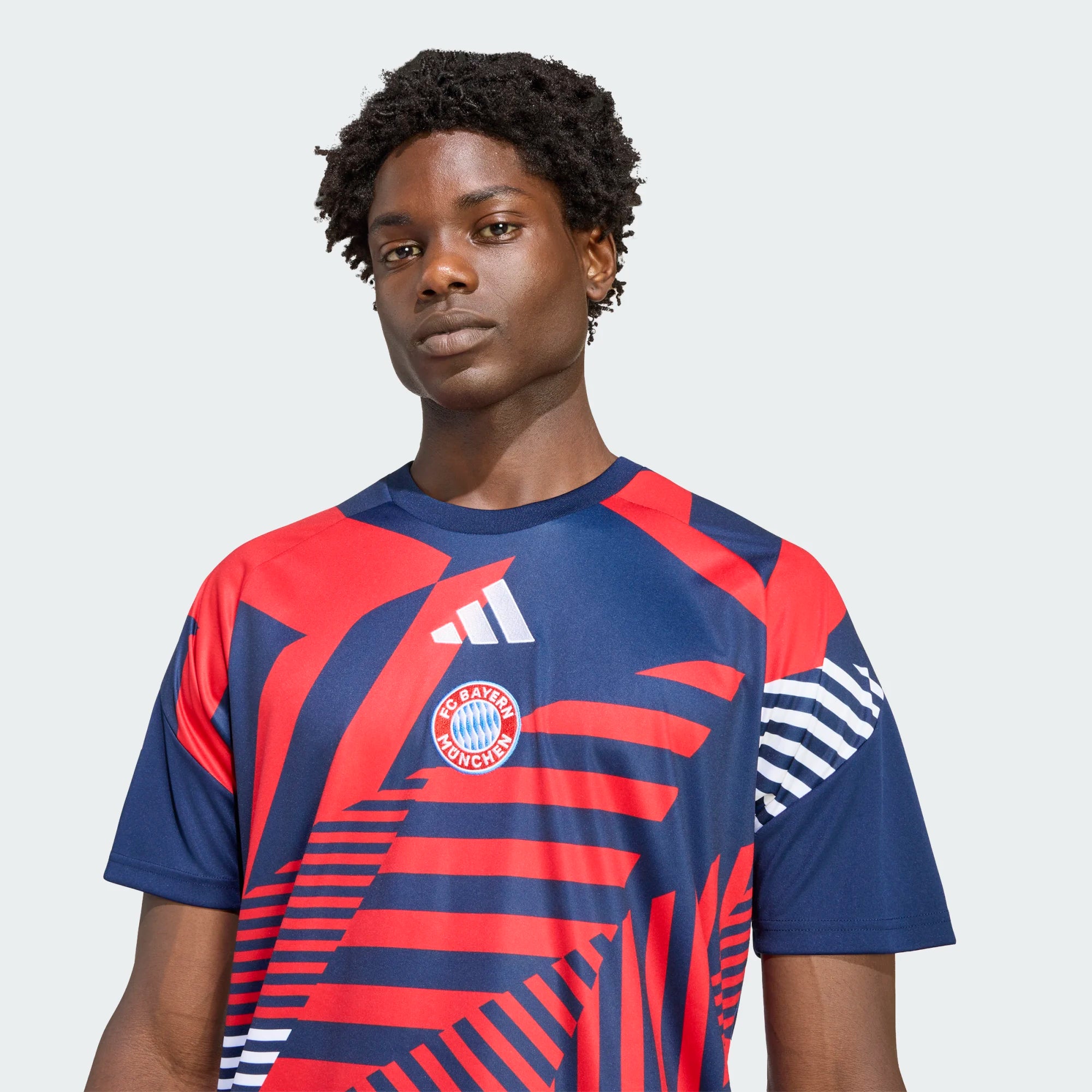 Person wearing a Bayern Munich soccer jersey with Adidas logo on a light gray background