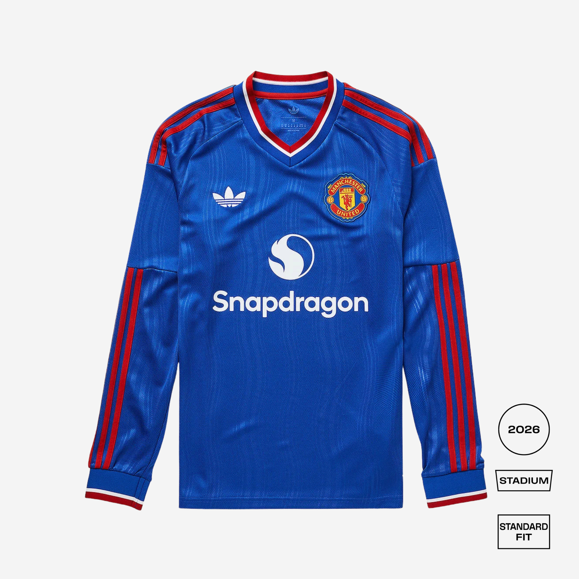 A blue long-sleeve Manchester United football jersey with red and white trim, featuring the Adidas logo, Manchester United crest, and Snapdragon sponsor logo. The image is set against a light gray background with fit and style labels on the bottom right.