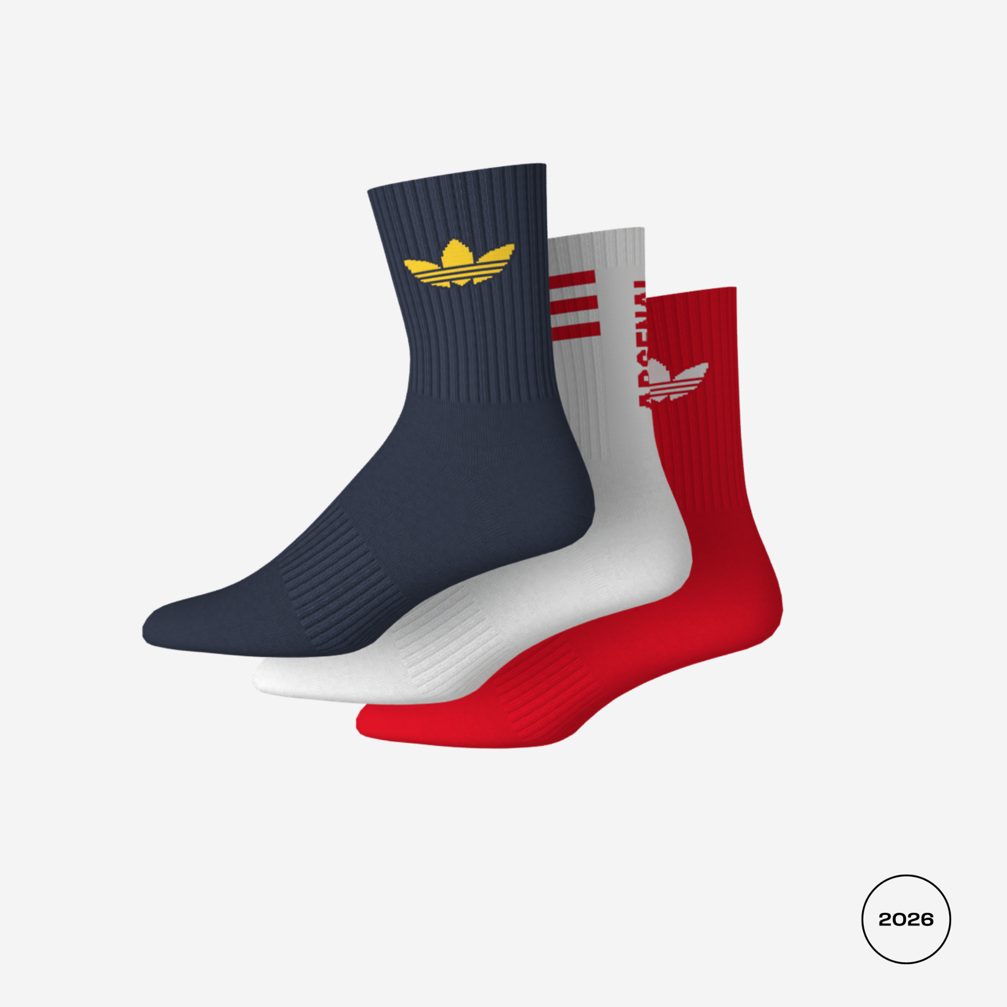 Three Adidas crew socks in navy, white, and red, arranged in a fan shape on a light gray background. The navy sock features a gold trefoil logo, the white sock has red stripes and a white trefoil logo, and the red sock has a red trefoil logo.