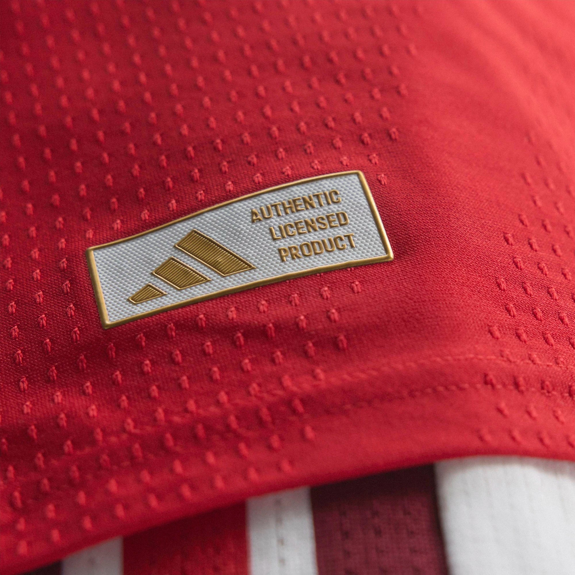 Red textured fabric with an 'Authentic Licensed Product' label featuring Adidas logo.