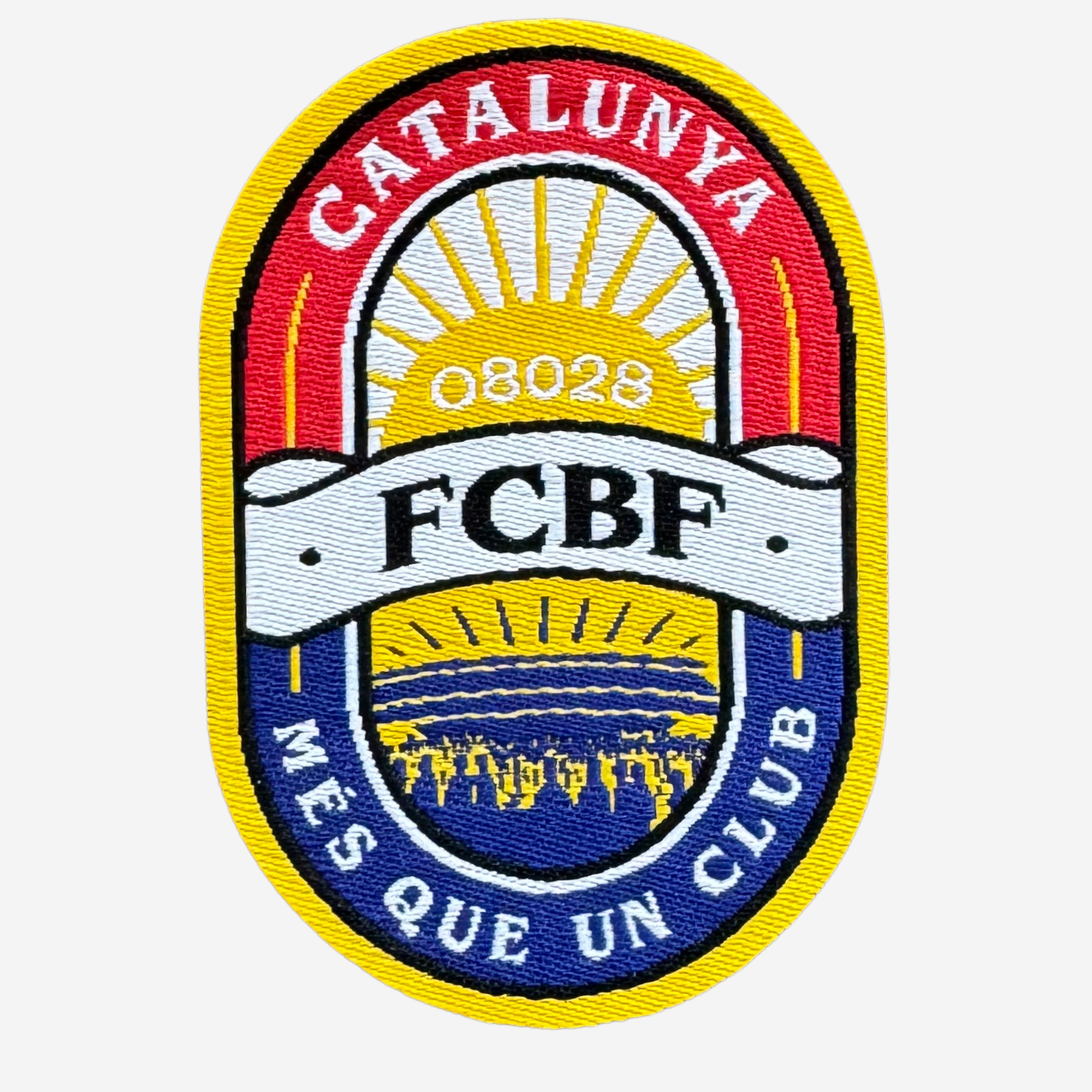 An embroidered oval patch with the text 'CATALUNYA' at the top, 'FCBF' on a white banner across the center, and 'MÉS QUE UN CLUB' along the bottom. The design features red, yellow, blue, and white sections with a sunburst motif and a small landscape detail at the bottom.