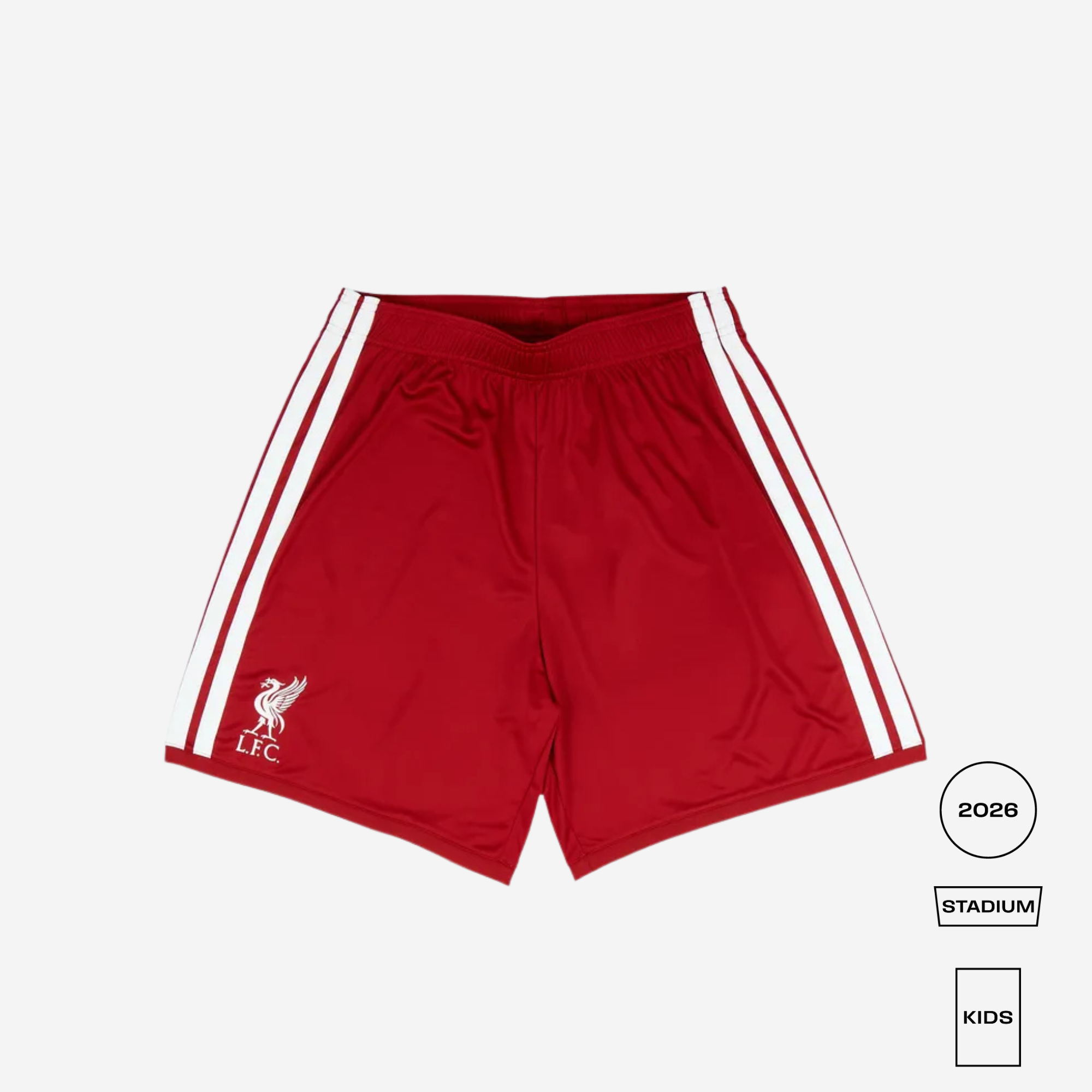 Red Liverpool football shorts with white side stripes and a white club crest on the left leg, shown flat on a light gray background with size/style labels at the bottom right.
