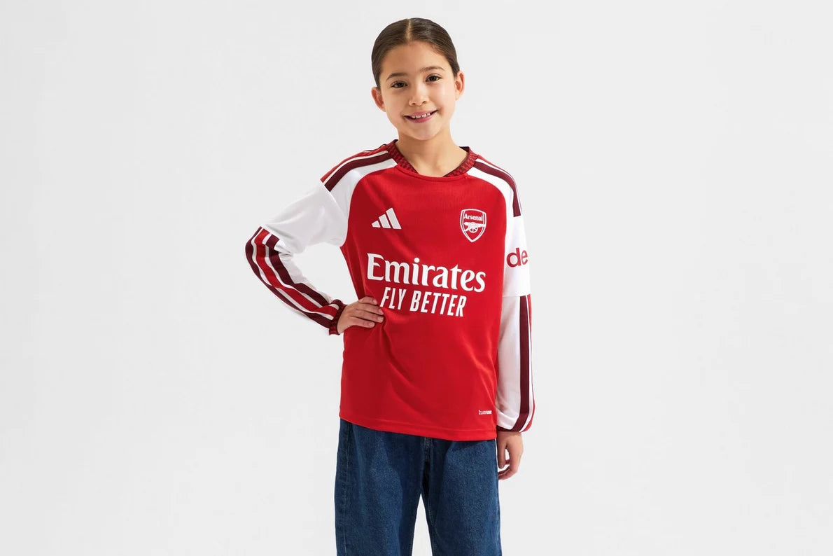 Child wearing a red sports jersey with visible branding on a white background