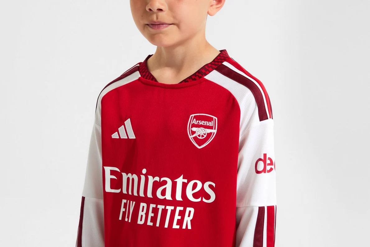 Child wearing a red and white Arsenal football jersey with Adidas logo on a light gray background